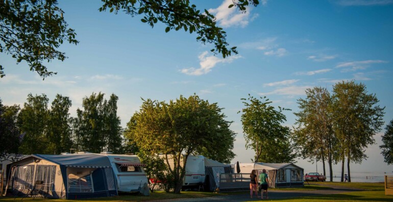 Husvagnar med vy över sjö.