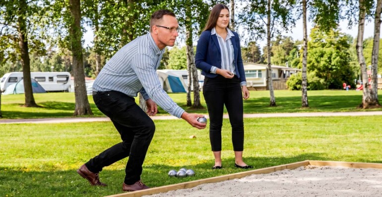 En man och en kvinna som spelar boule utomhus